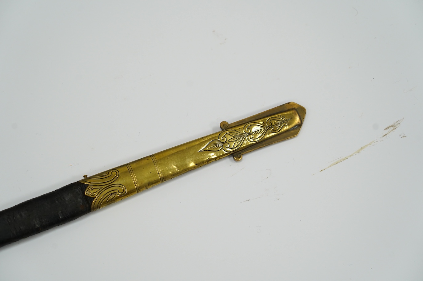 A Victorian warrant officer's sword by Westcott and Sons, regulation brass hilt, black fish skin covered grip, in its brass mounted leather scabbard, blade 79.5cm. Condition - well worn